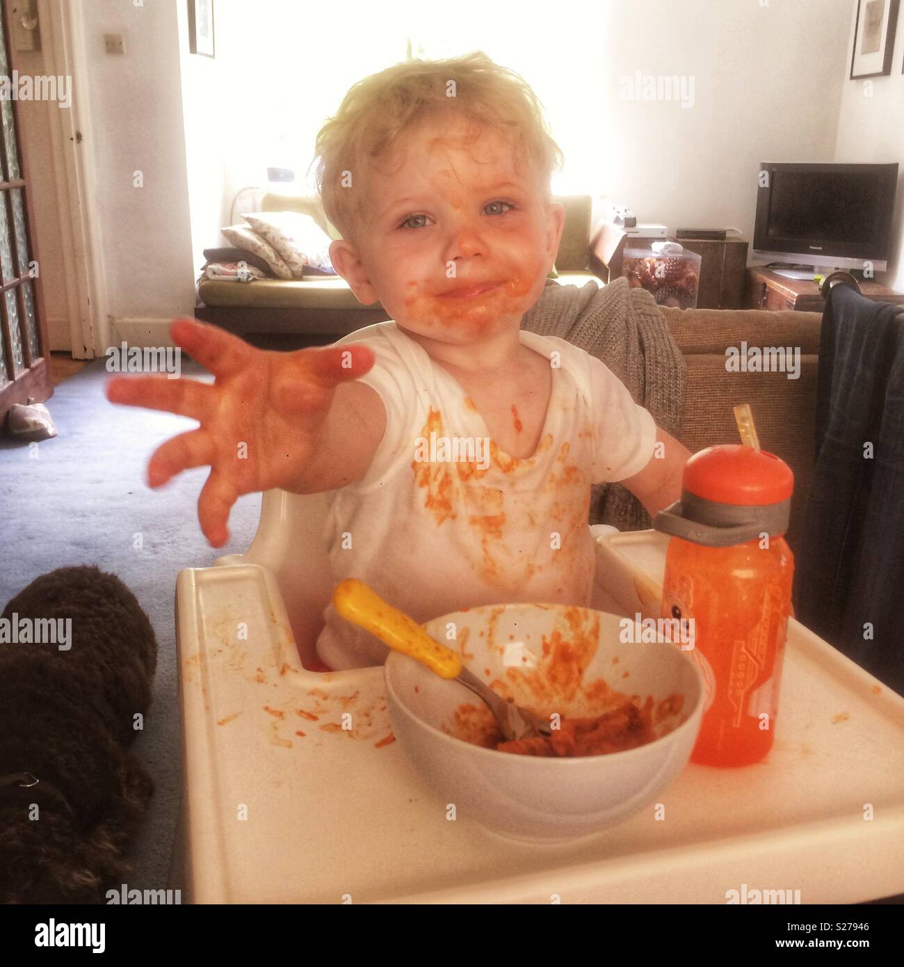 One year old baby boy eating pasta messily. Stock Photo
