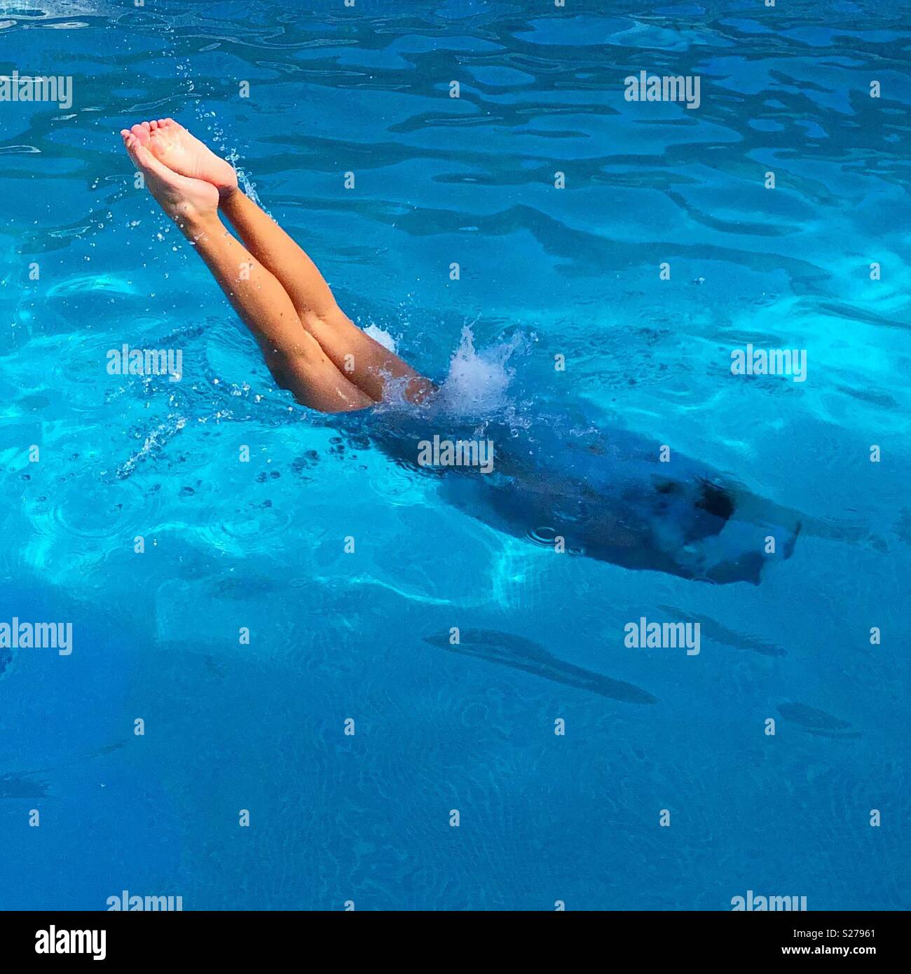 Girl diving into the swimming pool on a summer afternoon Stock Photo