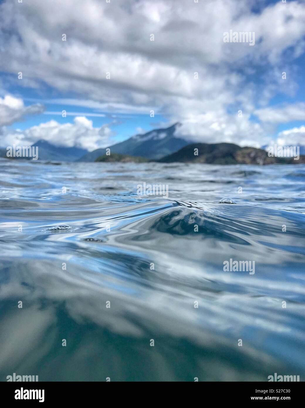 A view of Desolation Sound from water level with a feeling of motion and a view of mountains and sky in the background. Stock Photo