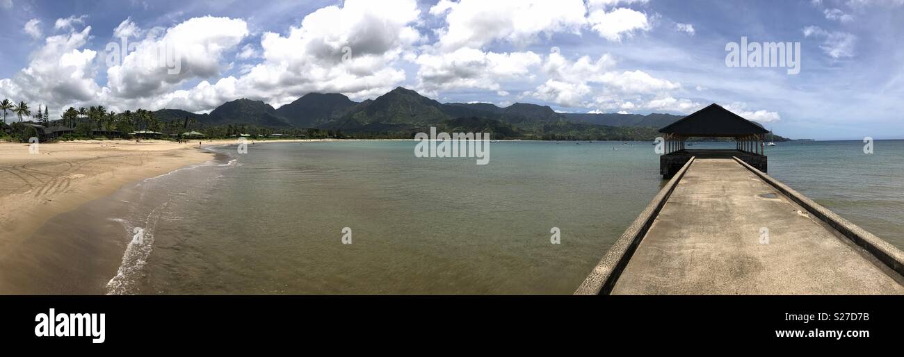 The historic Hanalei Pier and Bay, located on the island of Kauai, Hawaii, are shown in a panoramic view during a beautiful summer day. - Smartphone Captured Stock Image