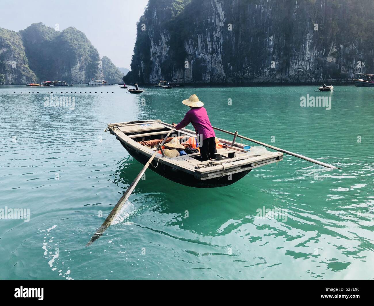 Man in rowing boat - Ha long bay Stock Photo