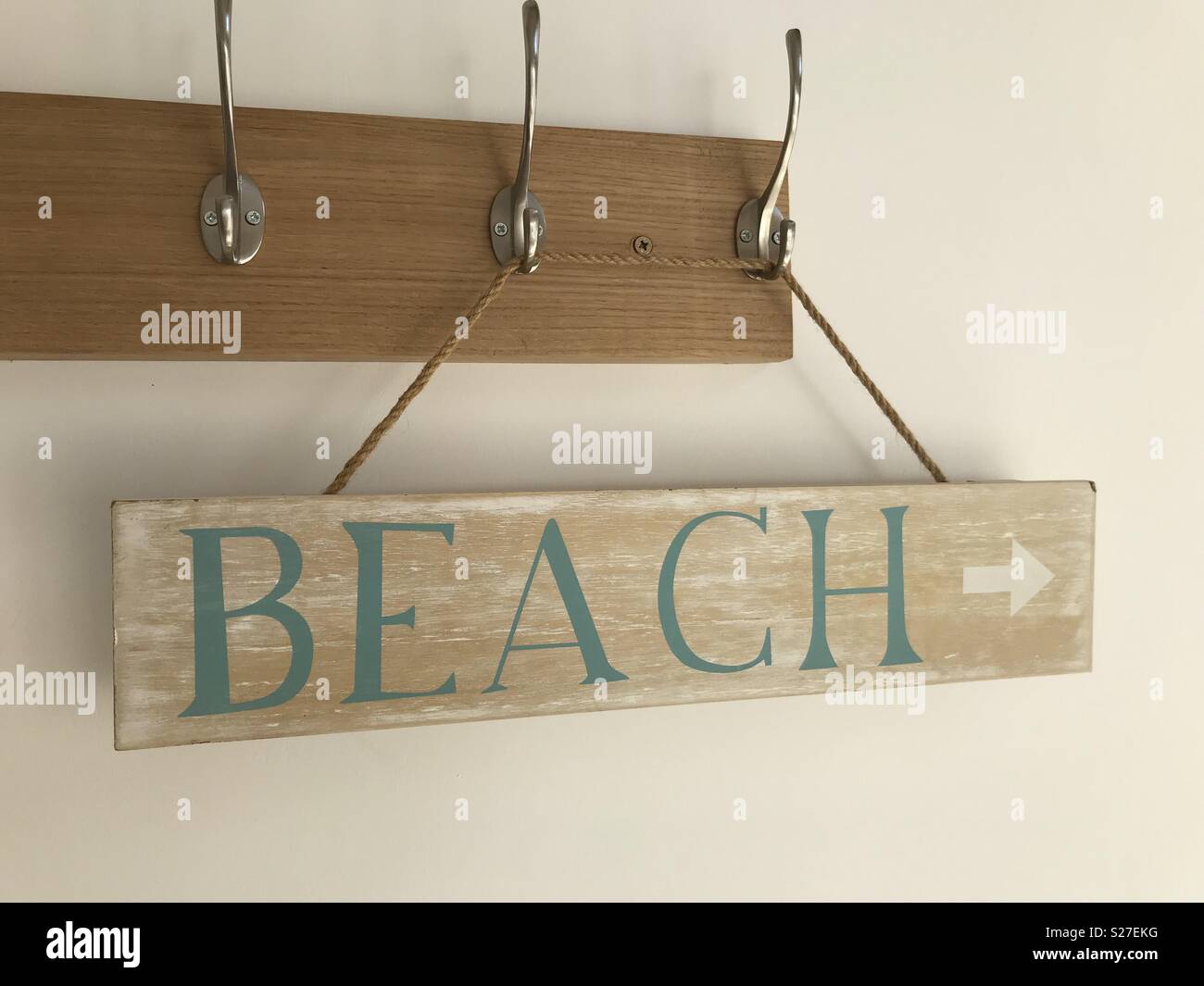 Beach sign hanging on coat hooks Stock Photo Alamy
