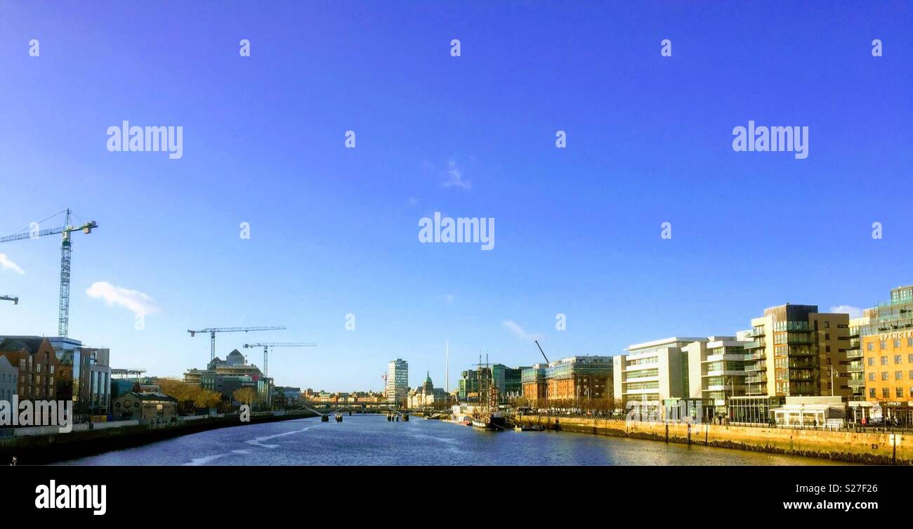 The cityscape of Dublin Ireland as viewed from the Samuel Becket Bridge with views of Liberty Hall, The Spire, and a number of construction cranes on the opposite side of the River Liffey. - Smartphone Captured Stock Image
