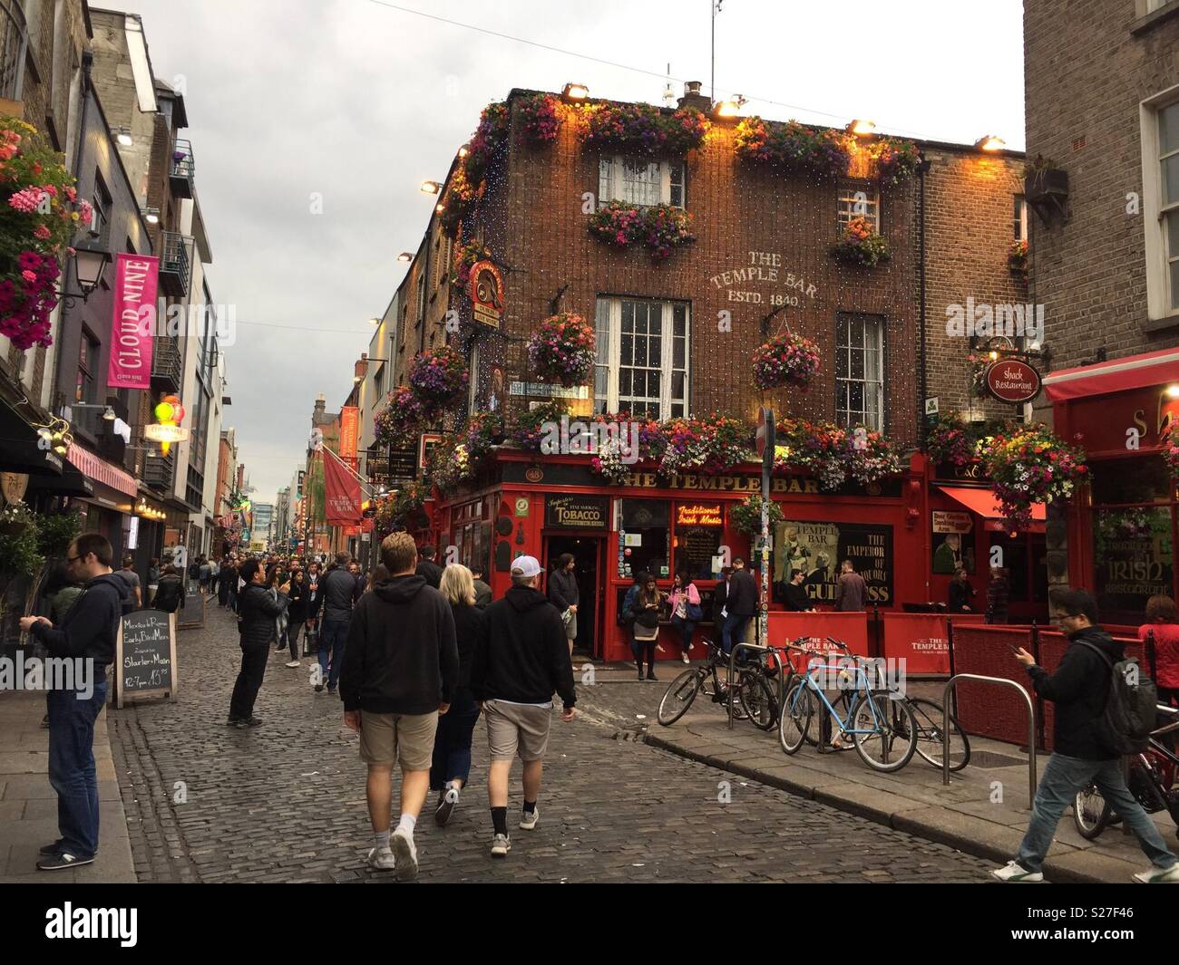 The Temple Bar Pub, est. 1840, in Dublin’s cultural quarter, famed for live music, flowers, and lively crowds on cobbled streets. - Smartphone Captured Stock Image