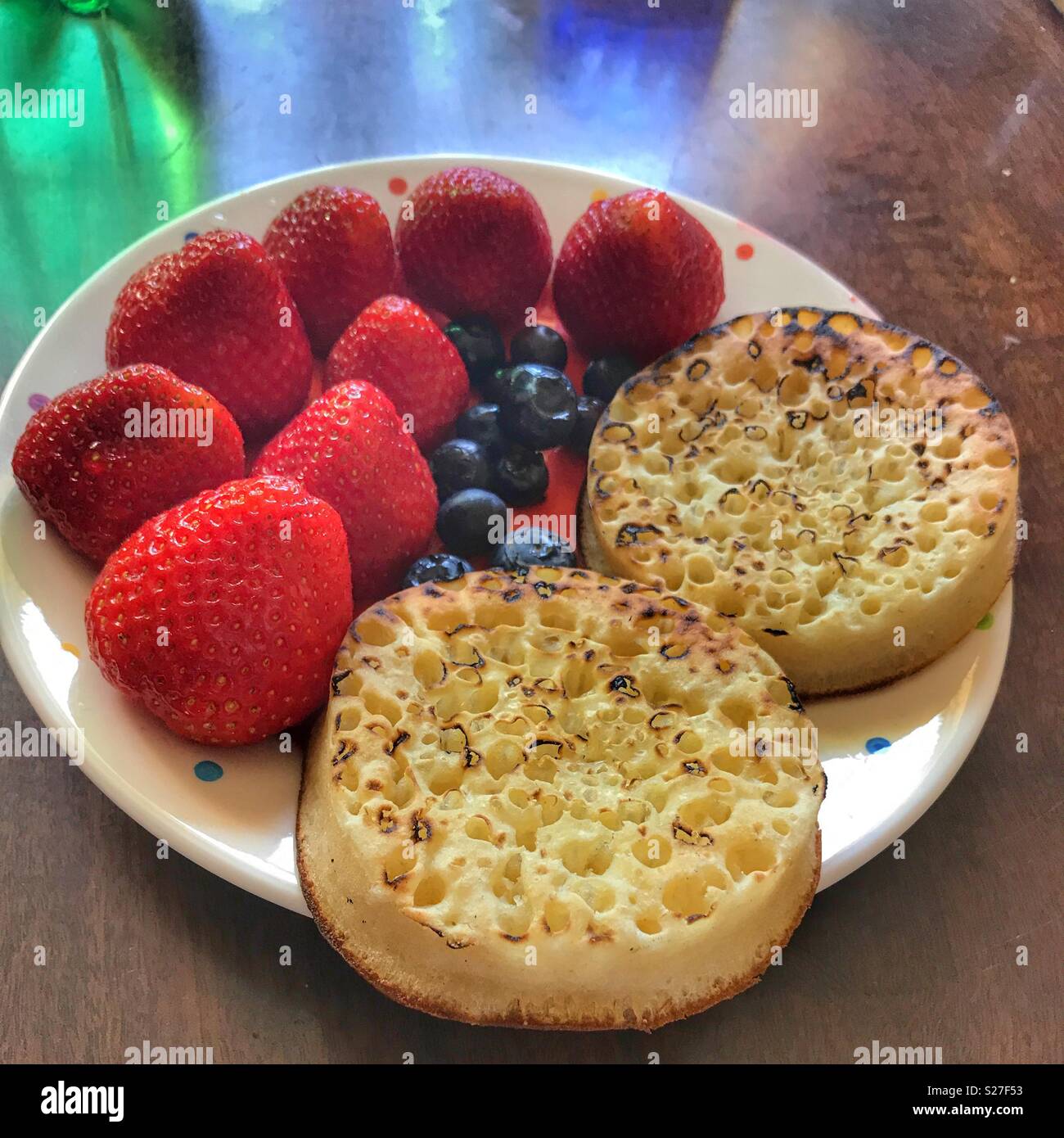 Plated meal, Crumpets, fresh strawberries and blueberries on a plate, high angle view Stock Photo