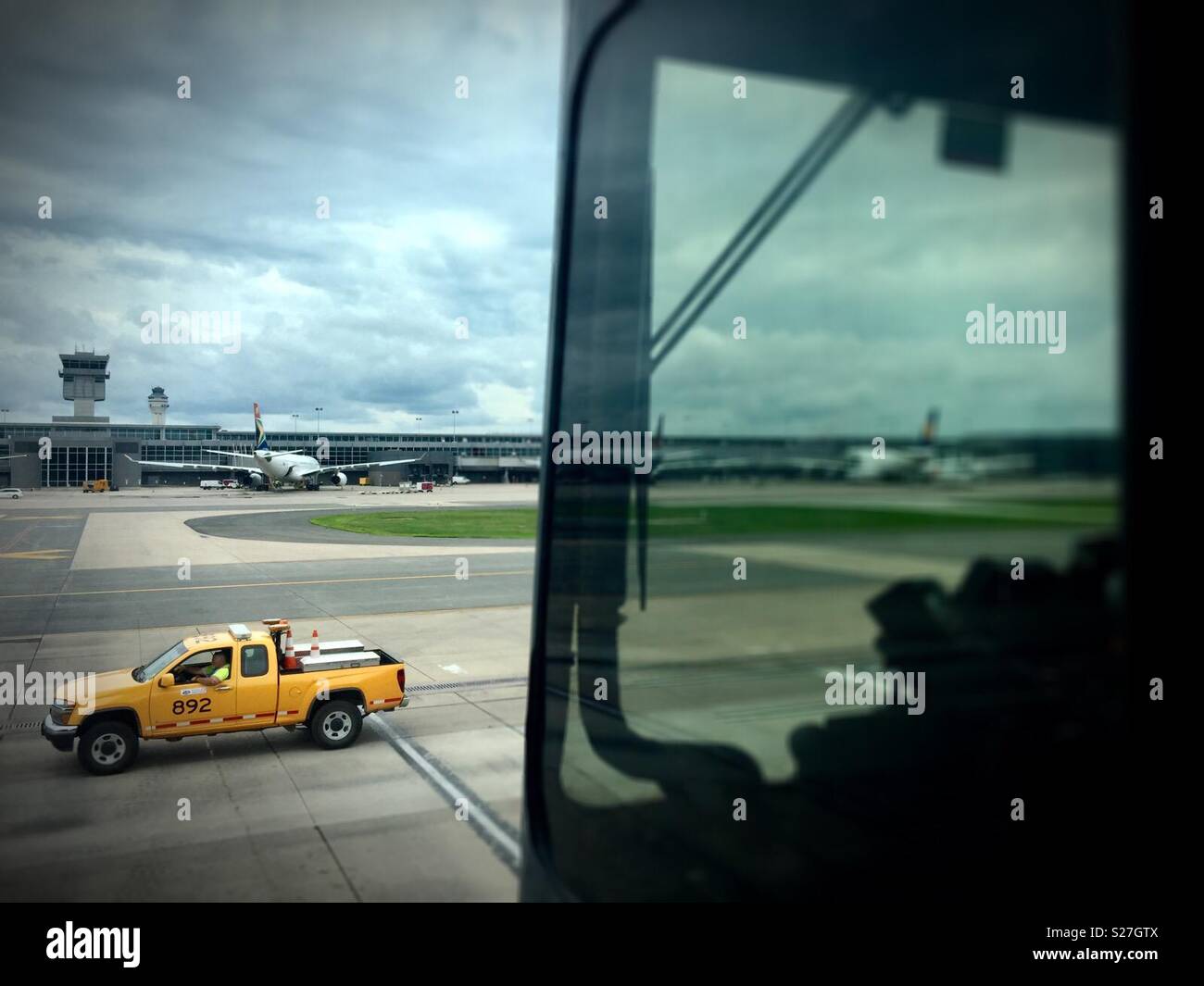 Sterling, Virginia, USA - June 27, 2018: A ground vehicle passes by a mobile passenger lounge taking airline passengers to a midfield terminal at Washington Dulles International Airport. Stock Photo