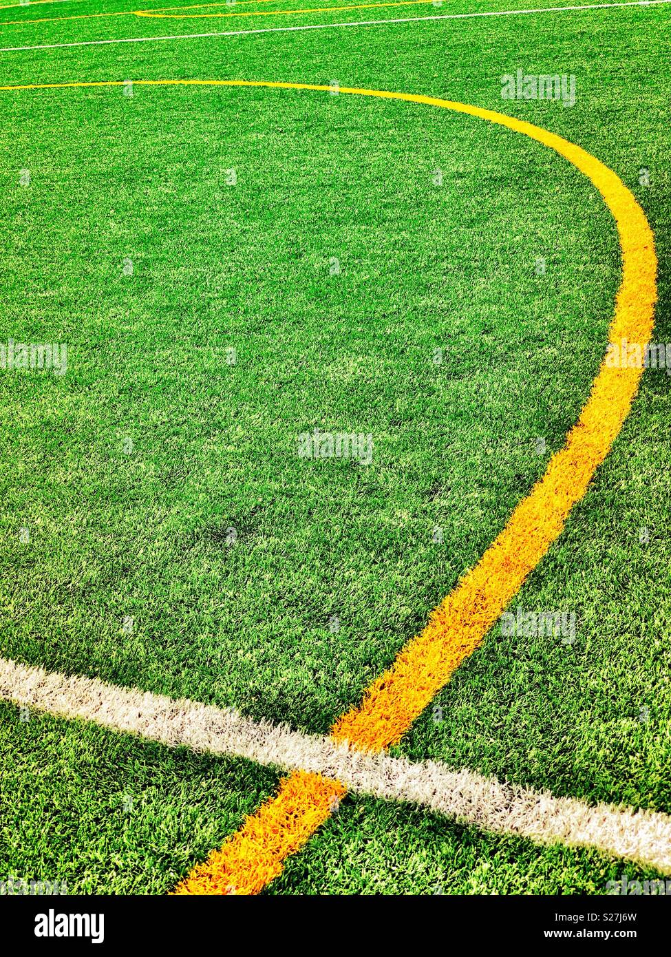 Soccer white and yellow field pitch demarcation lines, artificial turf, center circle, halfway line - Smartphone Captured Stock Image