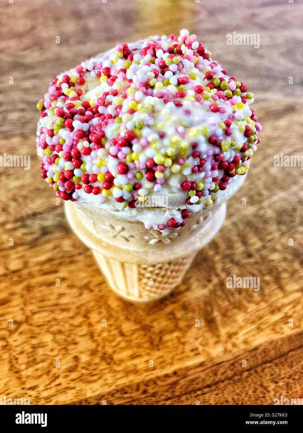 Ice cream in a cone with hundred and thousands on top of the ice cream. - Smartphone Captured Stock Image