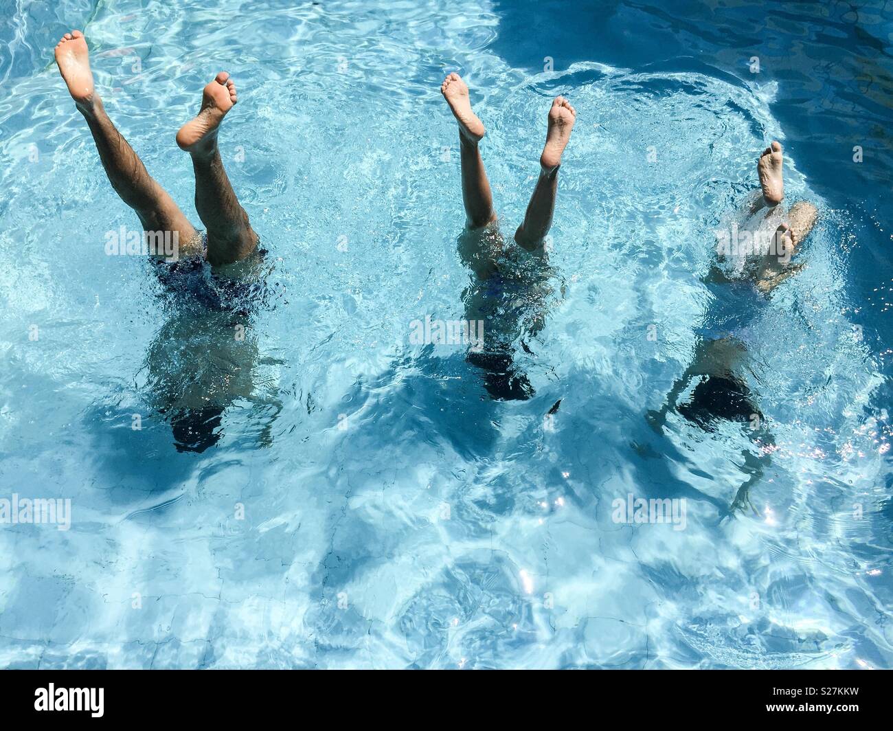 three teenagers doing balance in the pool - Smartphone Captured Stock Image