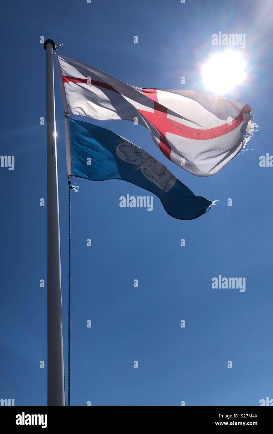 Sun shining on an England flag and a Yorkshire white rose flag, flying in the wind -  both attached to a flagpole - Smartphone Captured Stock Image Sun shining on an England flag and a Yorkshire white rose flag, flying in the wind -  both attached to a flagpole - Smartphone Captured Stock Image
