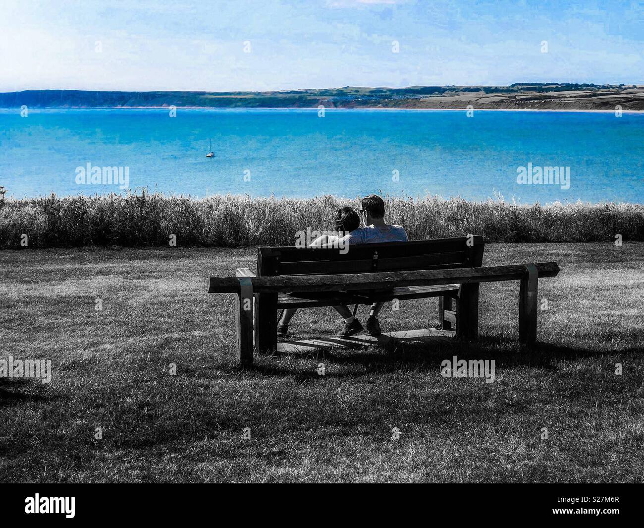 Romantic couple on a bench overlooking the sea - Smartphone Captured Stock Image