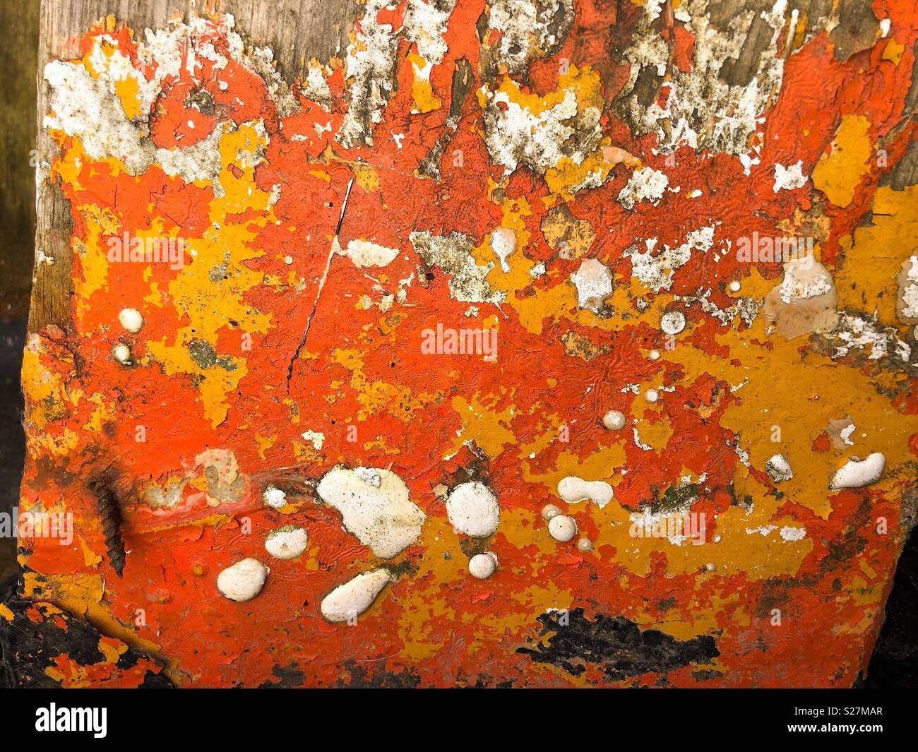 Orange, yellow and white paint flaking off the interior of an old boat - Smartphone Captured Stock Image