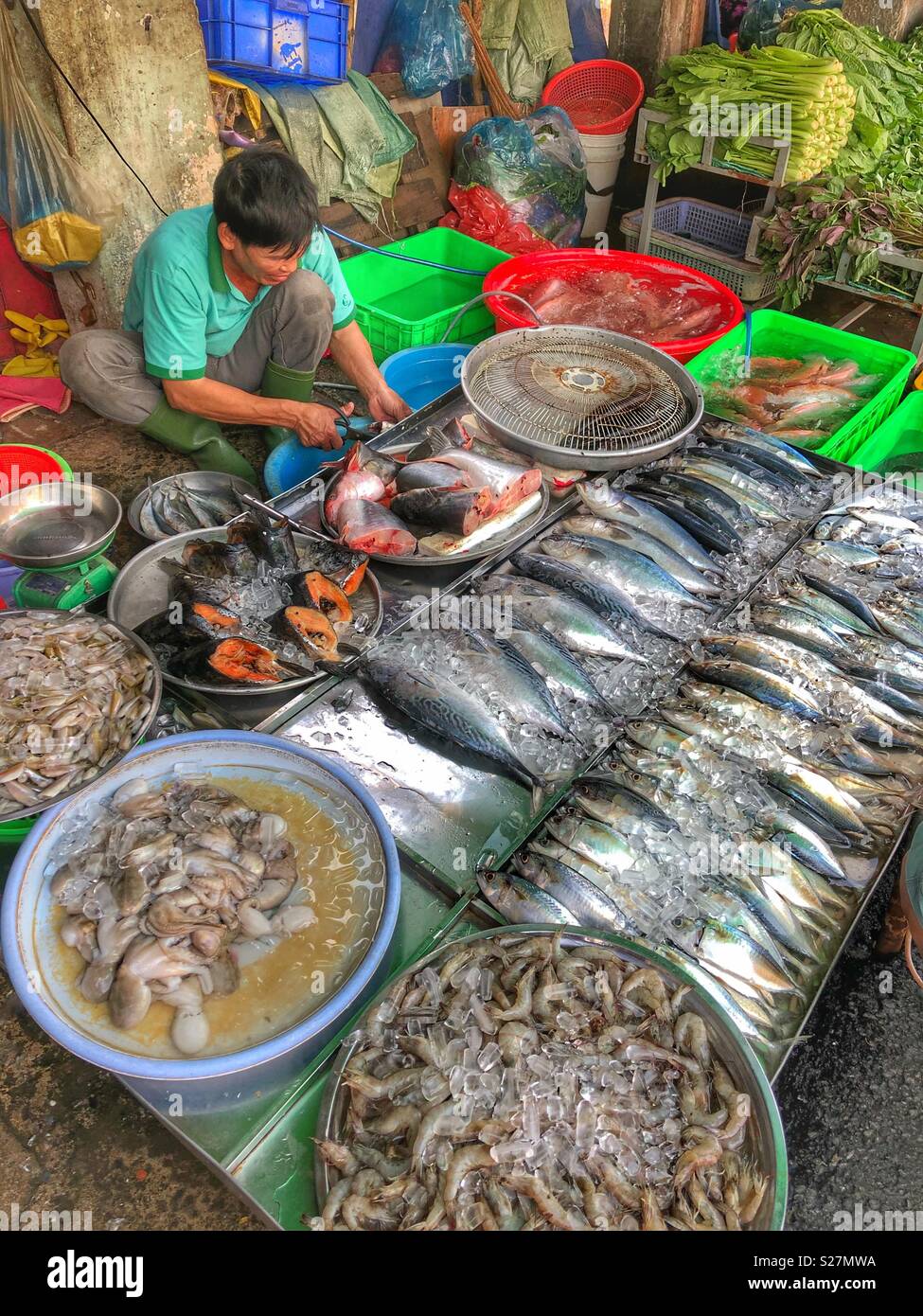 Fish vendor at an outdoor market in Ho Chi Minh City, Vietnam. - Smartphone Captured Stock Image