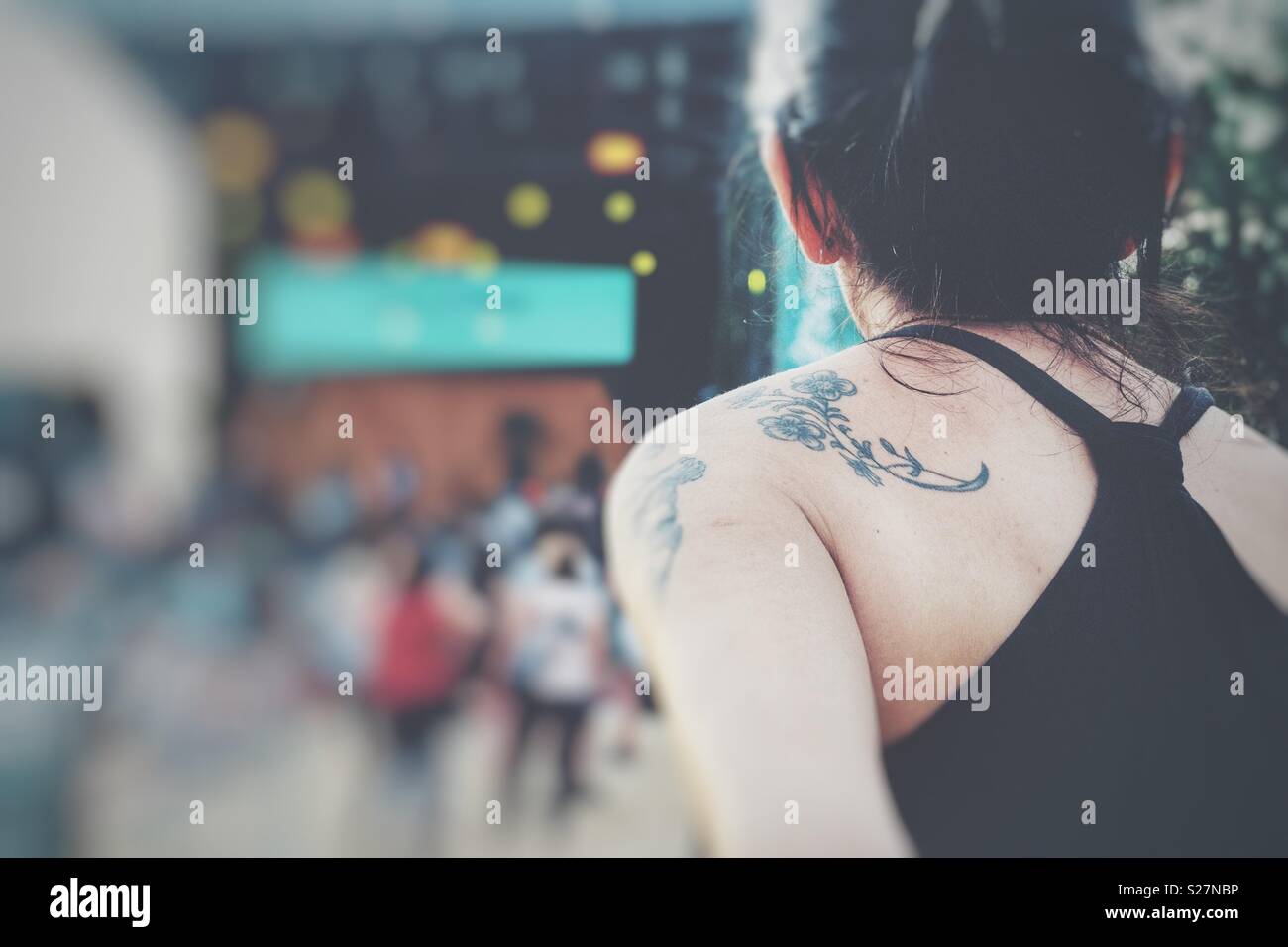 Tatooed dark haired woman enjoys a concert in summertime - Smartphone Captured Stock Image