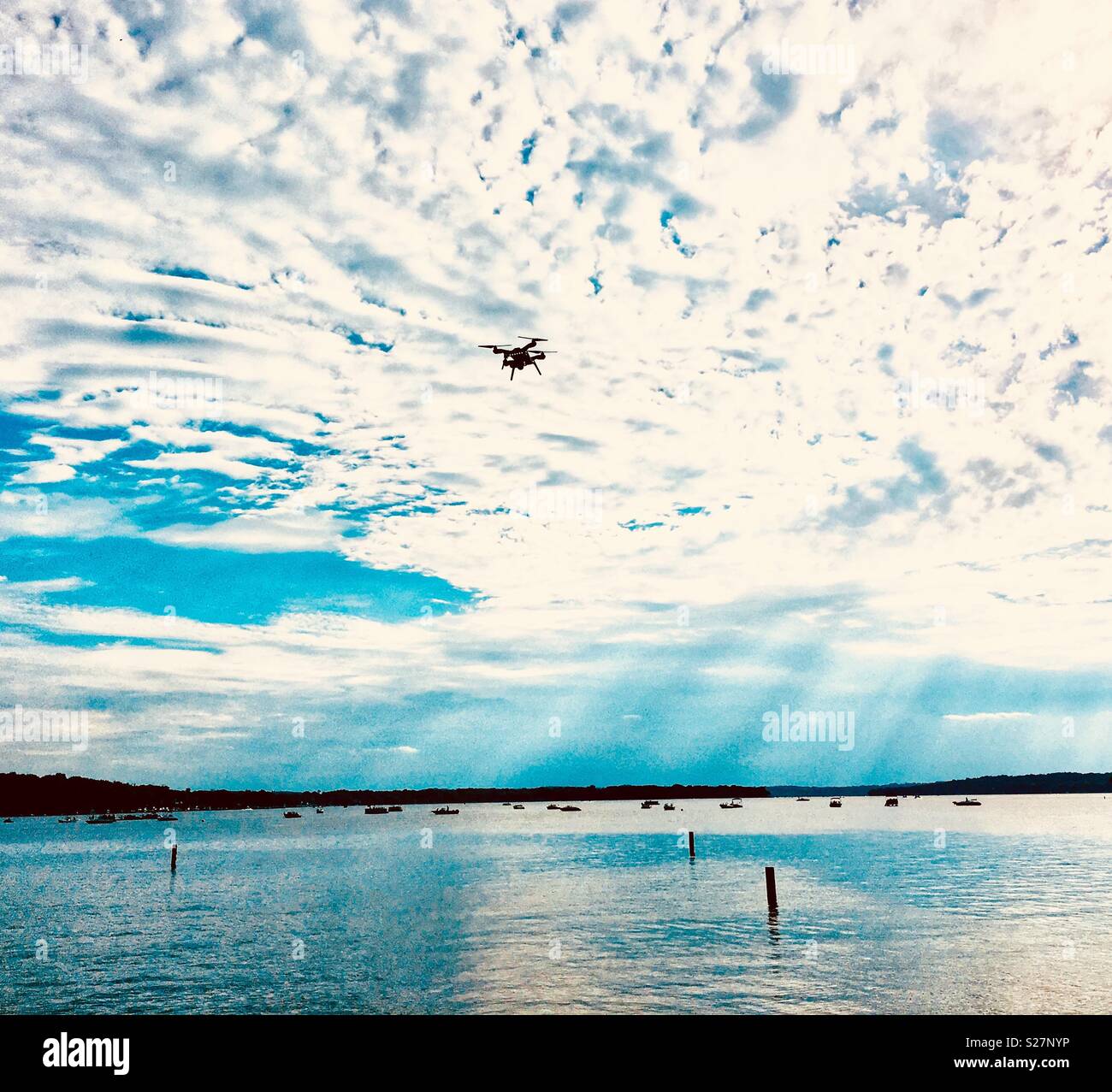 Drone flying over lake against the clouds - Smartphone Captured Stock Image
