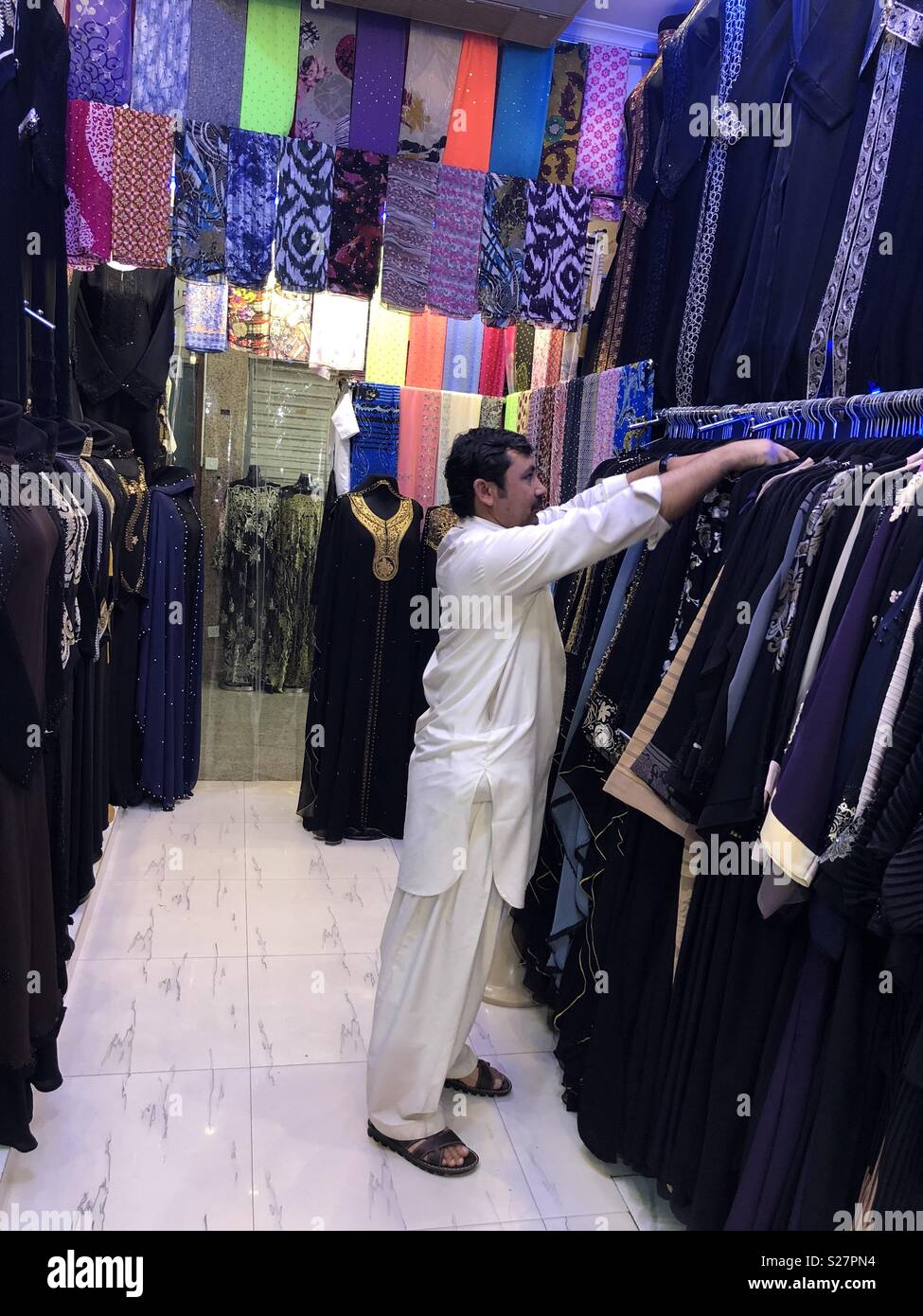 Man in abaya shop Stock Photo