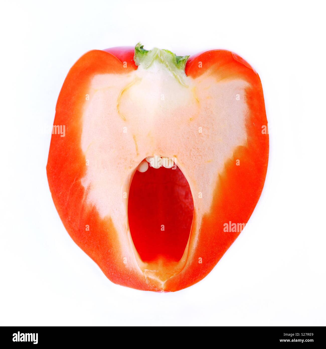 A sliced red pepper looking like a human face with a wide open mouth, appearing to shout or look scared - Smartphone Captured Stock Image