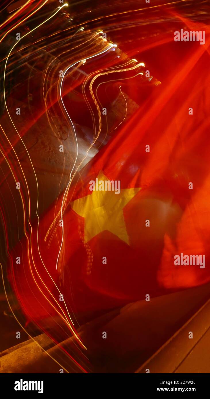 Night time abstract of street scene and Vietnamese flag taken in Hoi An