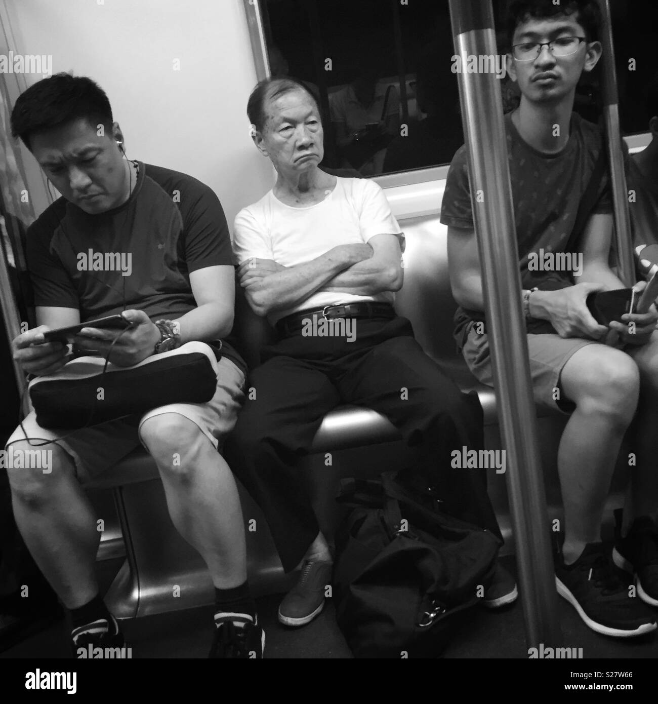 Grumpy-looking man on the MTR, Hong Kong Stock Photo