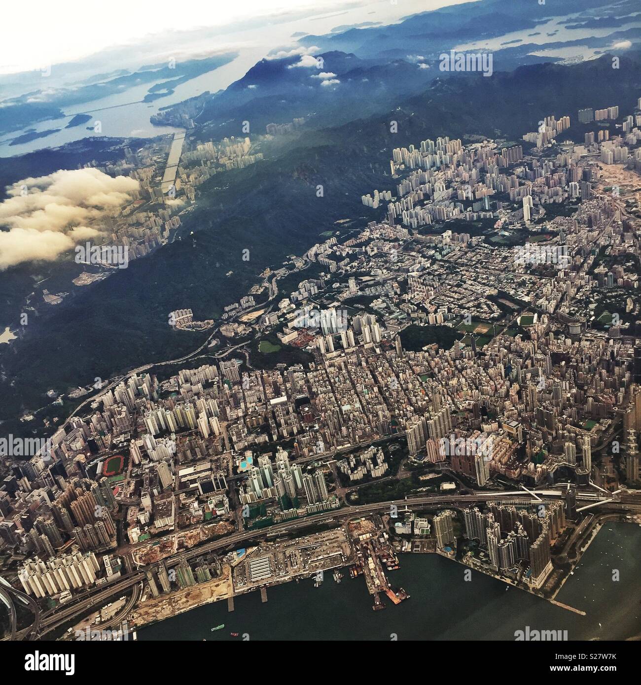 Kowloon, looking east across Sham Shui Po to Kowloon Tong and San Po Kong, with Sha Tin to the north of the 'Nine Dragons' mountains that give Kowloon its name, seen from a jet departing Hong Kong - Smartphone Captured Stock Image