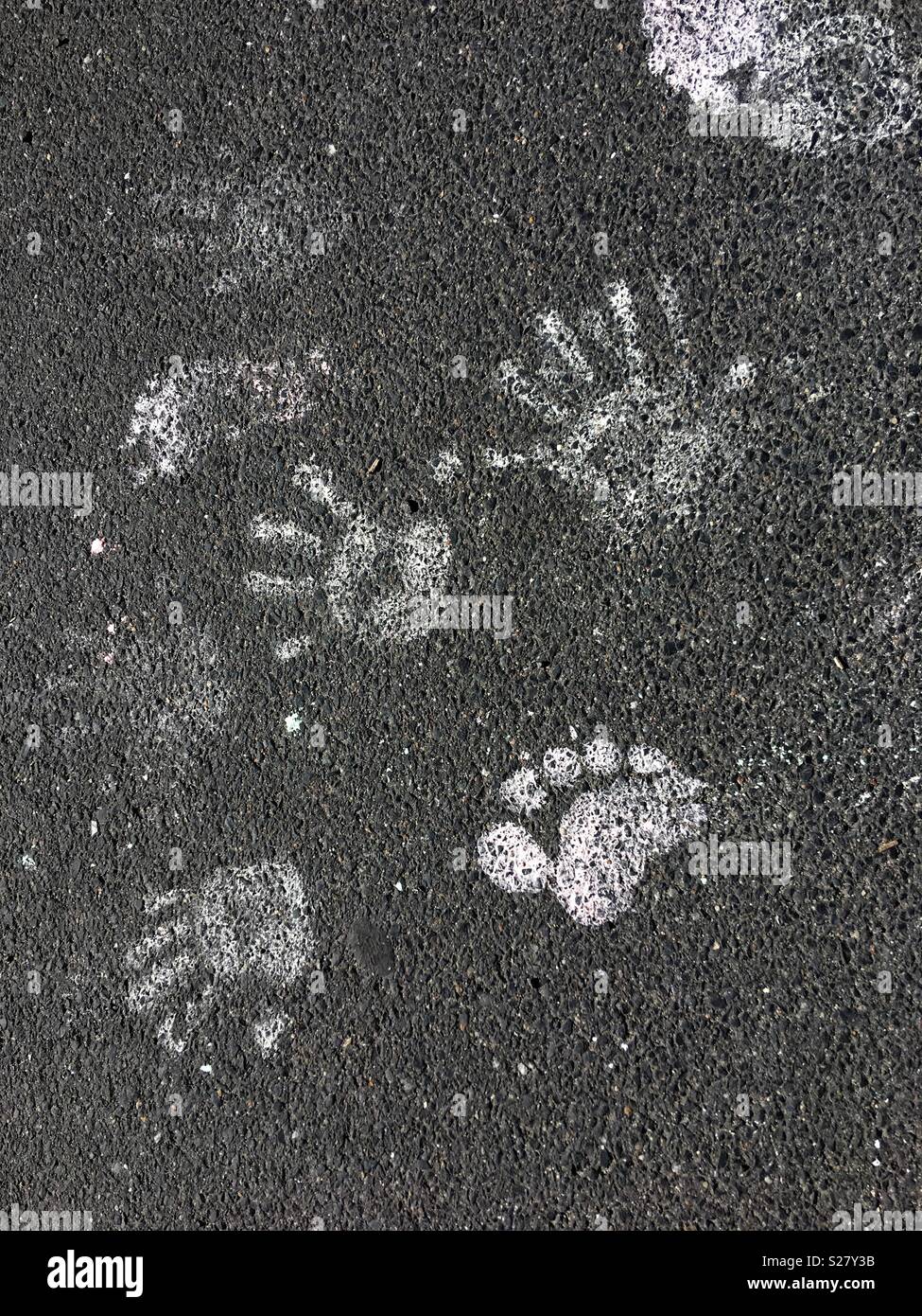 White hand and foot prints on the tarmac Stock Photo