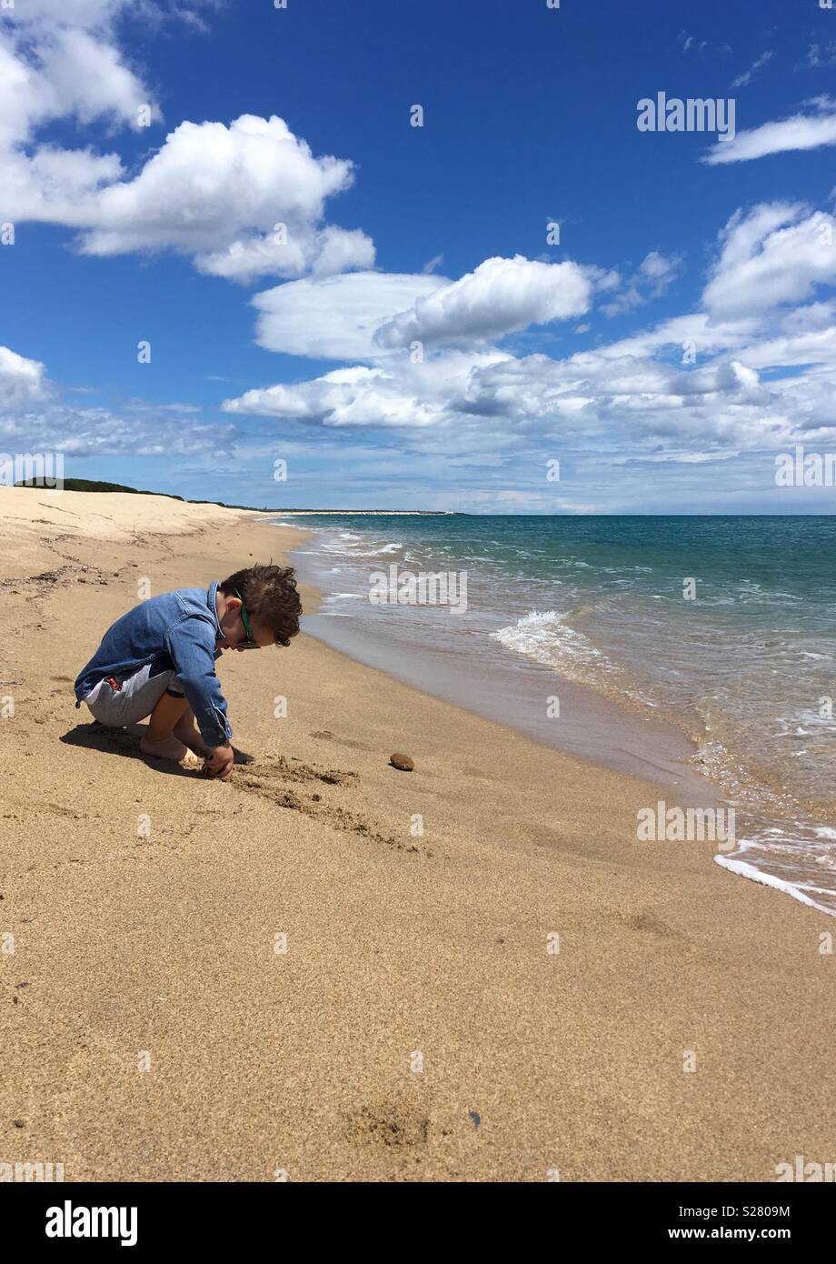 A boy searching for treasures, Sardinia, Su Barone beach Stock Photo