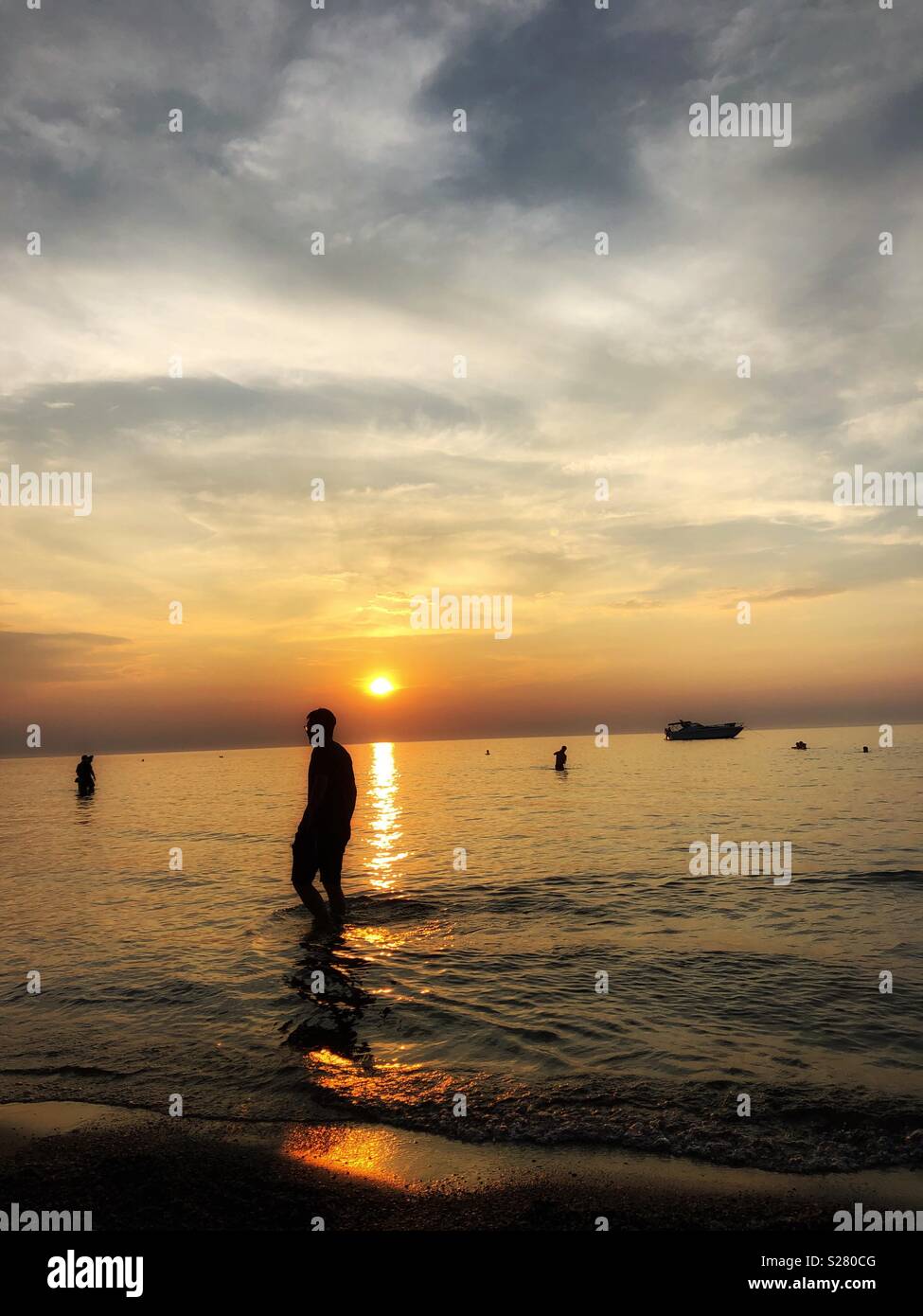 Silhouettes as the sun sets on the horizon. - Smartphone Captured Stock Image