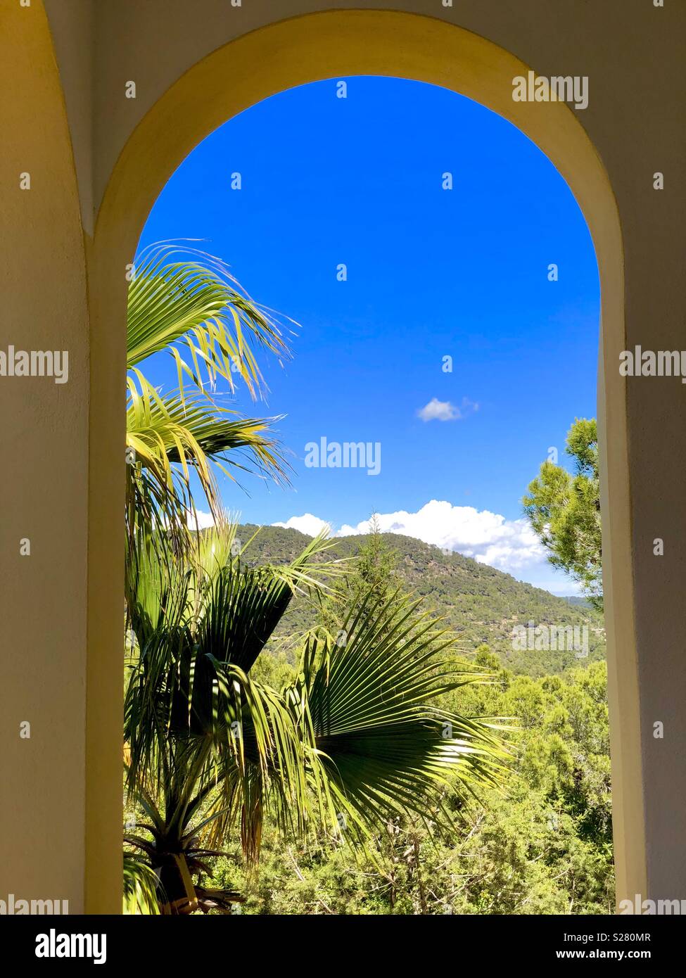 View through an arched window on blue sky and beautiful landscape - Smartphone Captured Stock Image