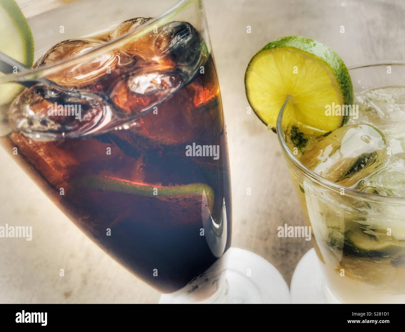 Mojito cocktail with ice and a slice, And a rum and coke with ice and a