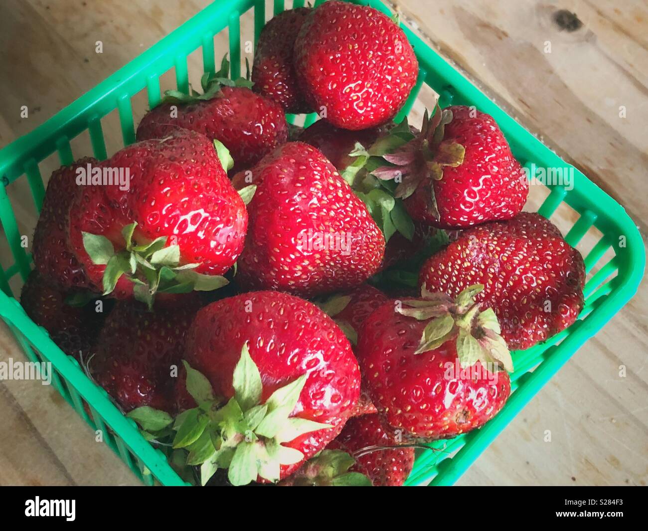 Quart of fresh picked Ontario strawberries on a wooden table Stock Photo