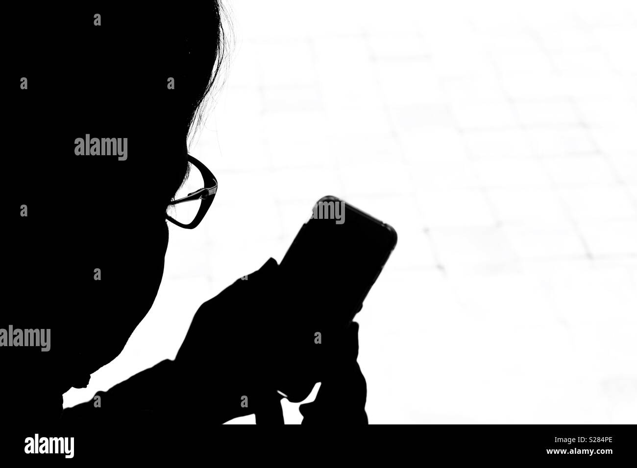 Silhouette of person checking messages on mobile phone - Smartphone Captured Stock Image