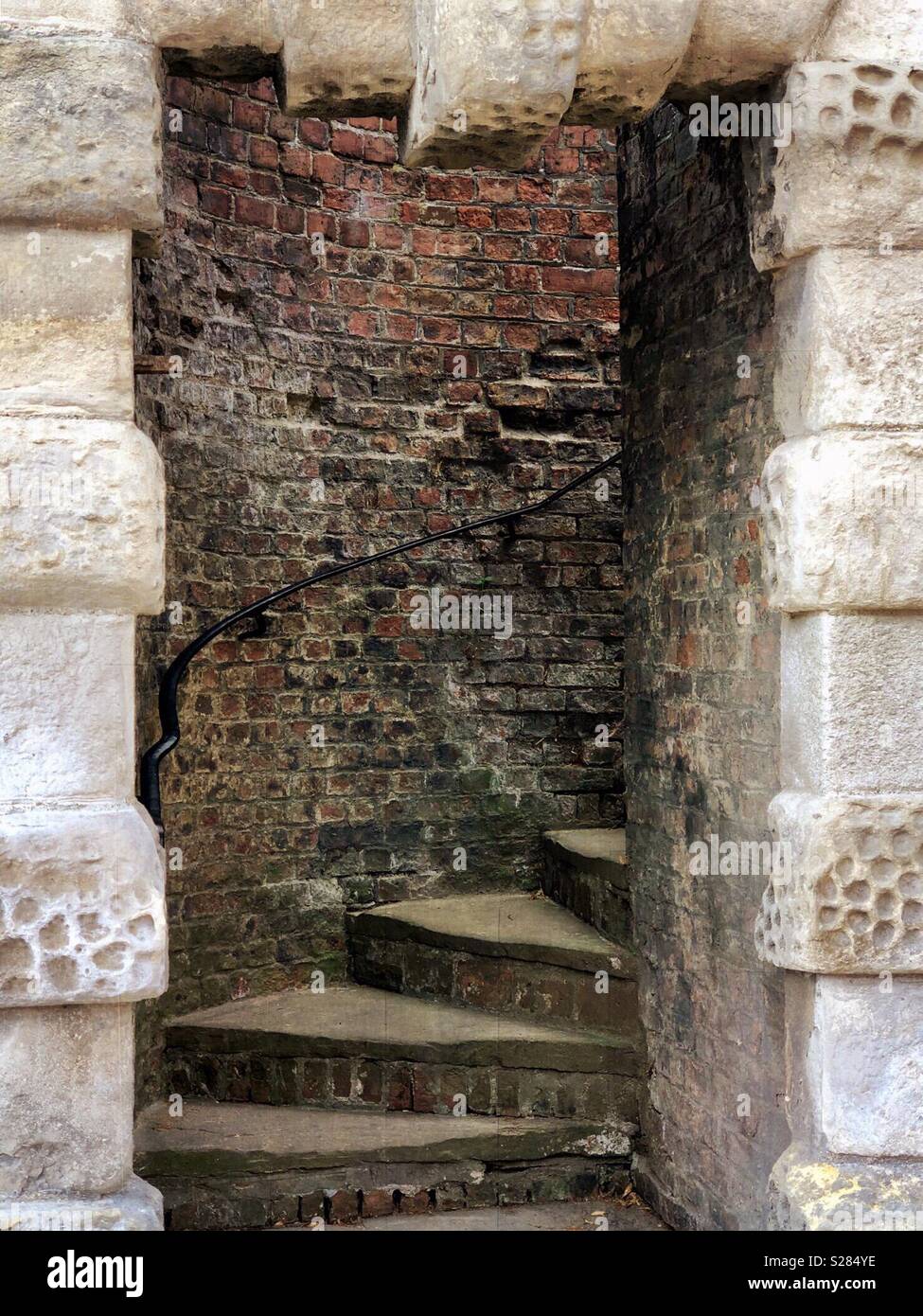 Stone steps spiral upwards viewed through an old, stone doorway - Smartphone Captured Stock Image