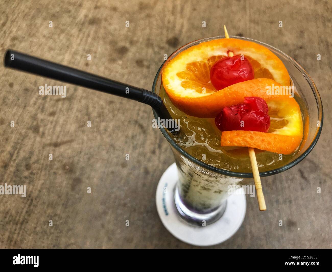 Cocktail, in a cocktail glass with a twist of orange and two cherries, high angle view Stock Photo