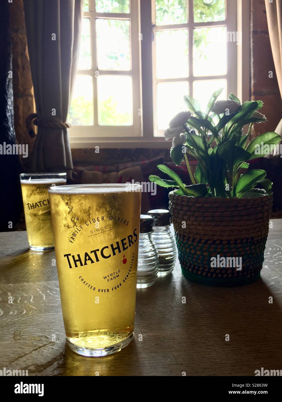 Drinking Thatchers apple cider at a pub at Stow-on-the-Wold, The Cotswolds, England UK - Smartphone Captured Stock Image