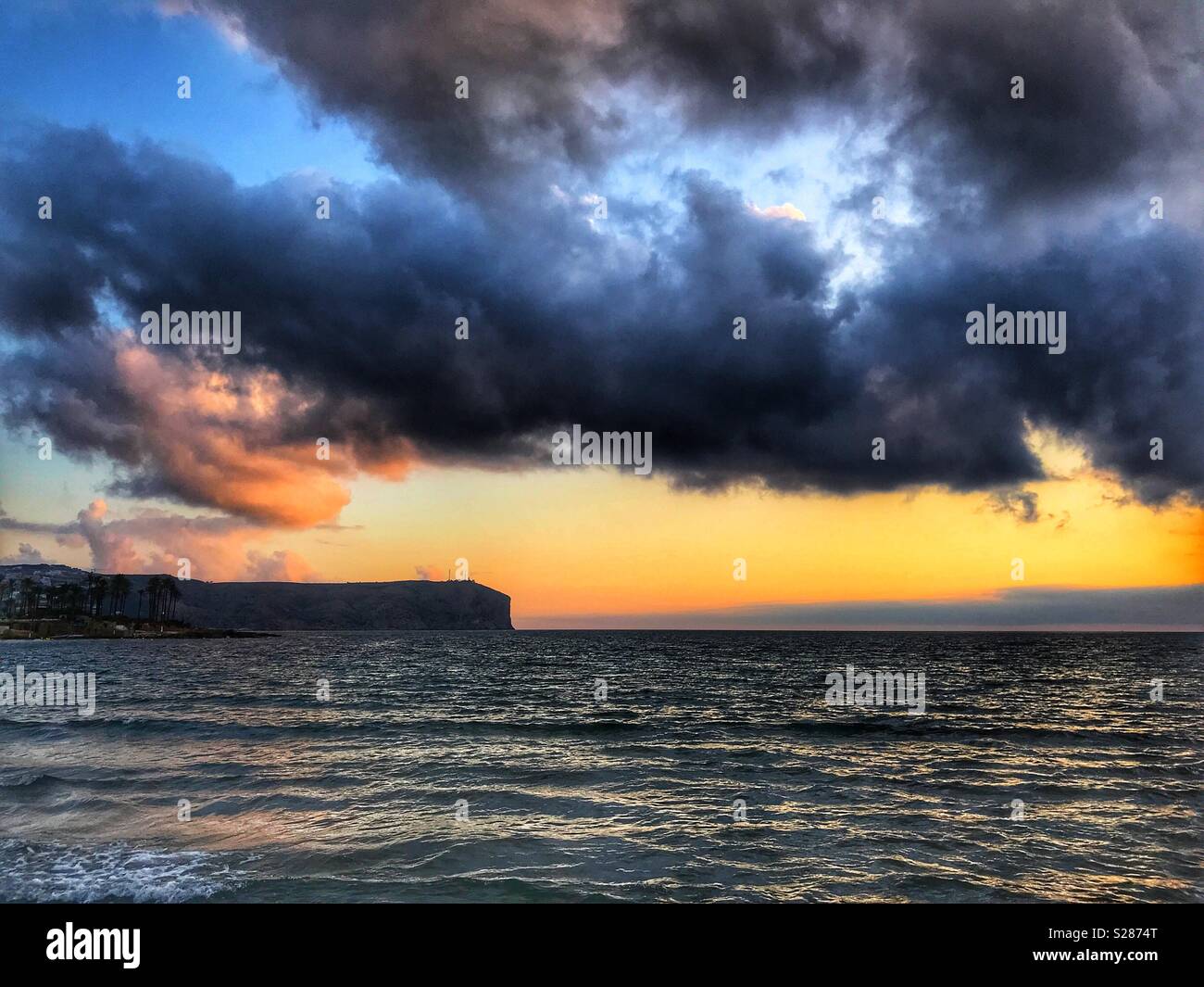 Sunrise over calm sea and Cabo San Antonio, Javea, Xabia, Alicante, Spain Stock Photo