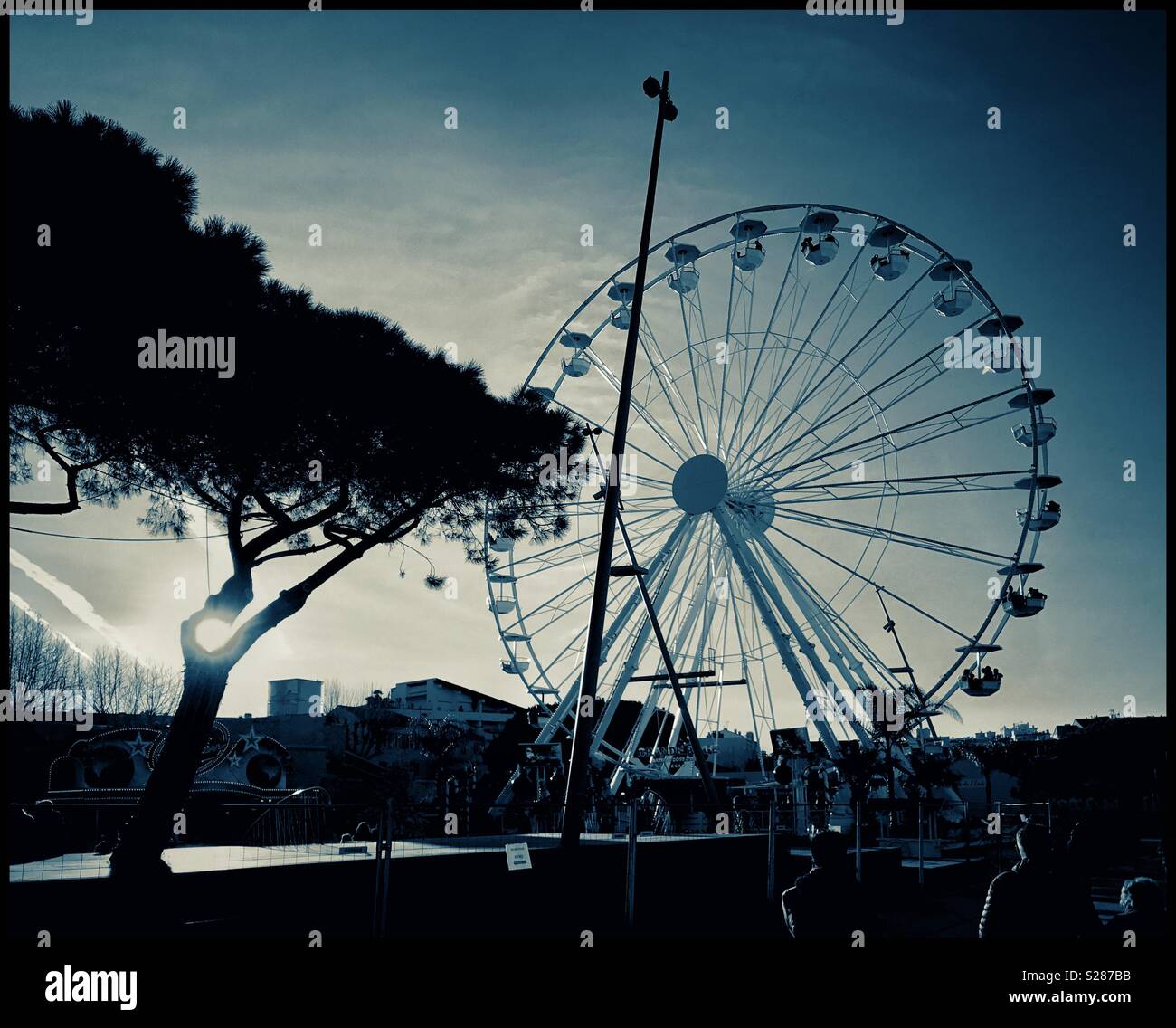 The Ferris Wheel on Esplanade du Pré aux Pecheurs in Antibes, on the Côte d’Azure in Mediterranean France. Late afternoon creates silhouettes. Photo Credit - © COLIN HOSKINS. - Smartphone Captured Stock Image