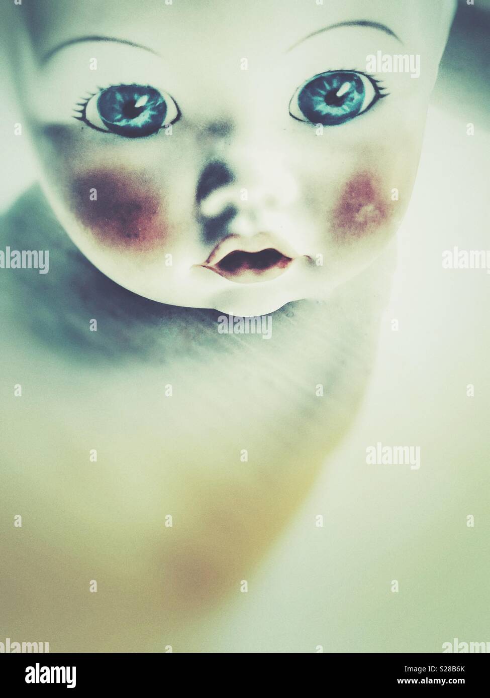A baby doll head with big eyes and red cheeks Stock Photo