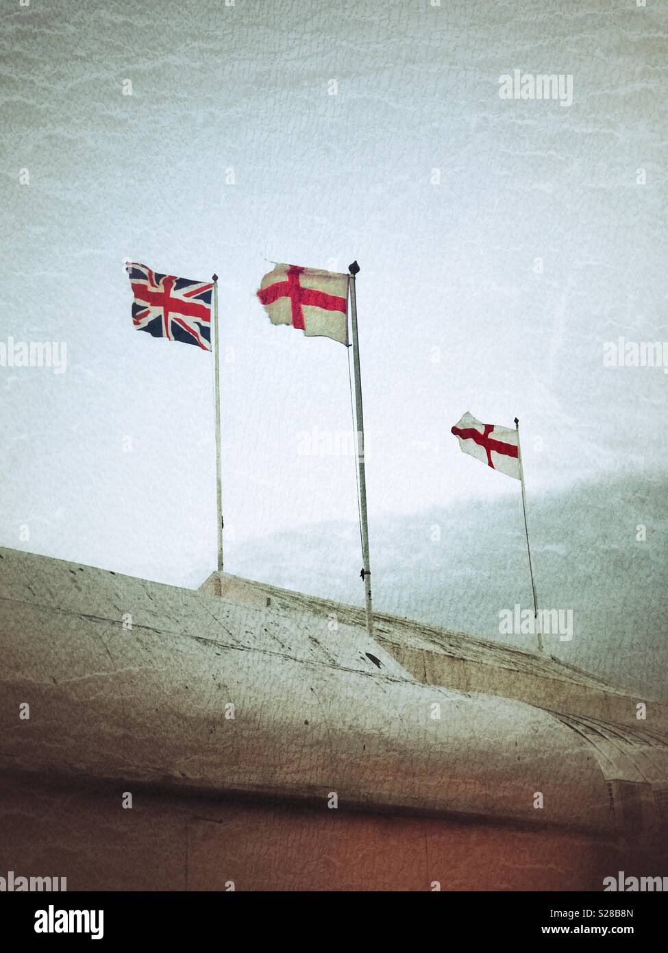 The Union Jack and flags of St George fluttering on top of the pier at Burnham-on-Sea, Somerset - Smartphone Captured Stock Image