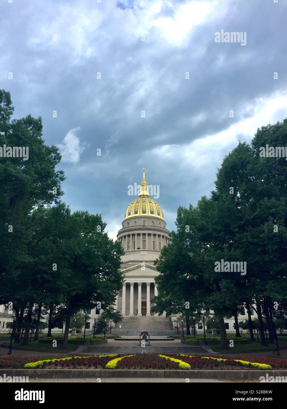 Charleston, West Virginia, USA - July 24, 2018: The gold dome of the West Virginia State Capitol building stands out against a stormy sky on a late summer afternoon. Stock Photo