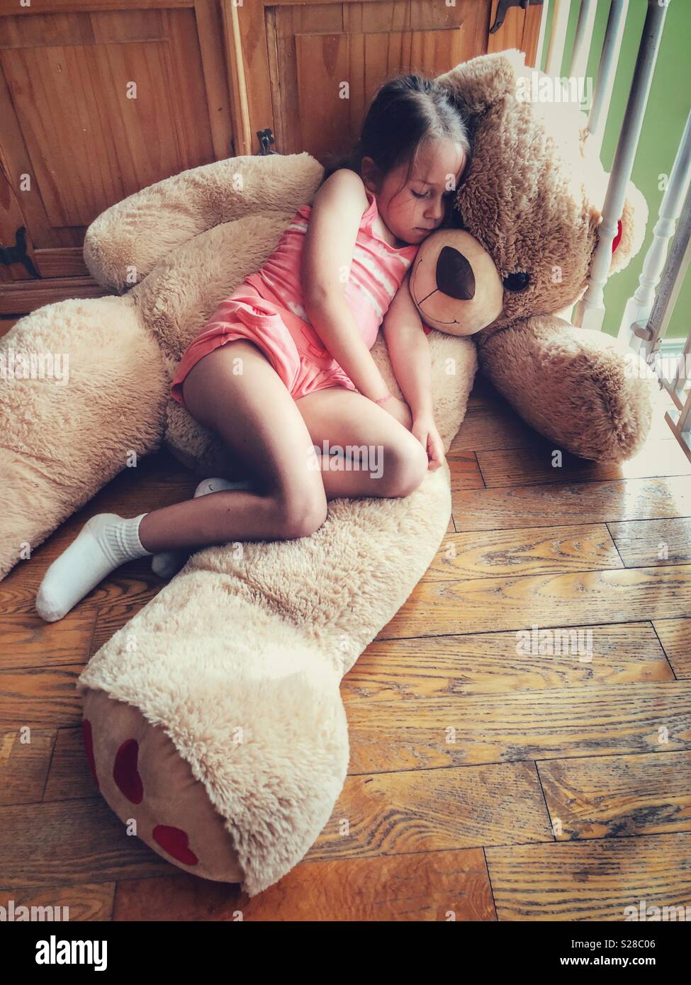 girl hugging giant teddy bear
