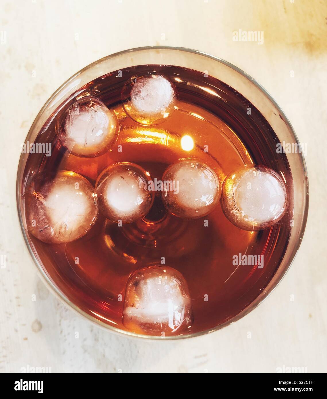 Glass of gin with rose mixer and ice cubes shot from above Stock Photo