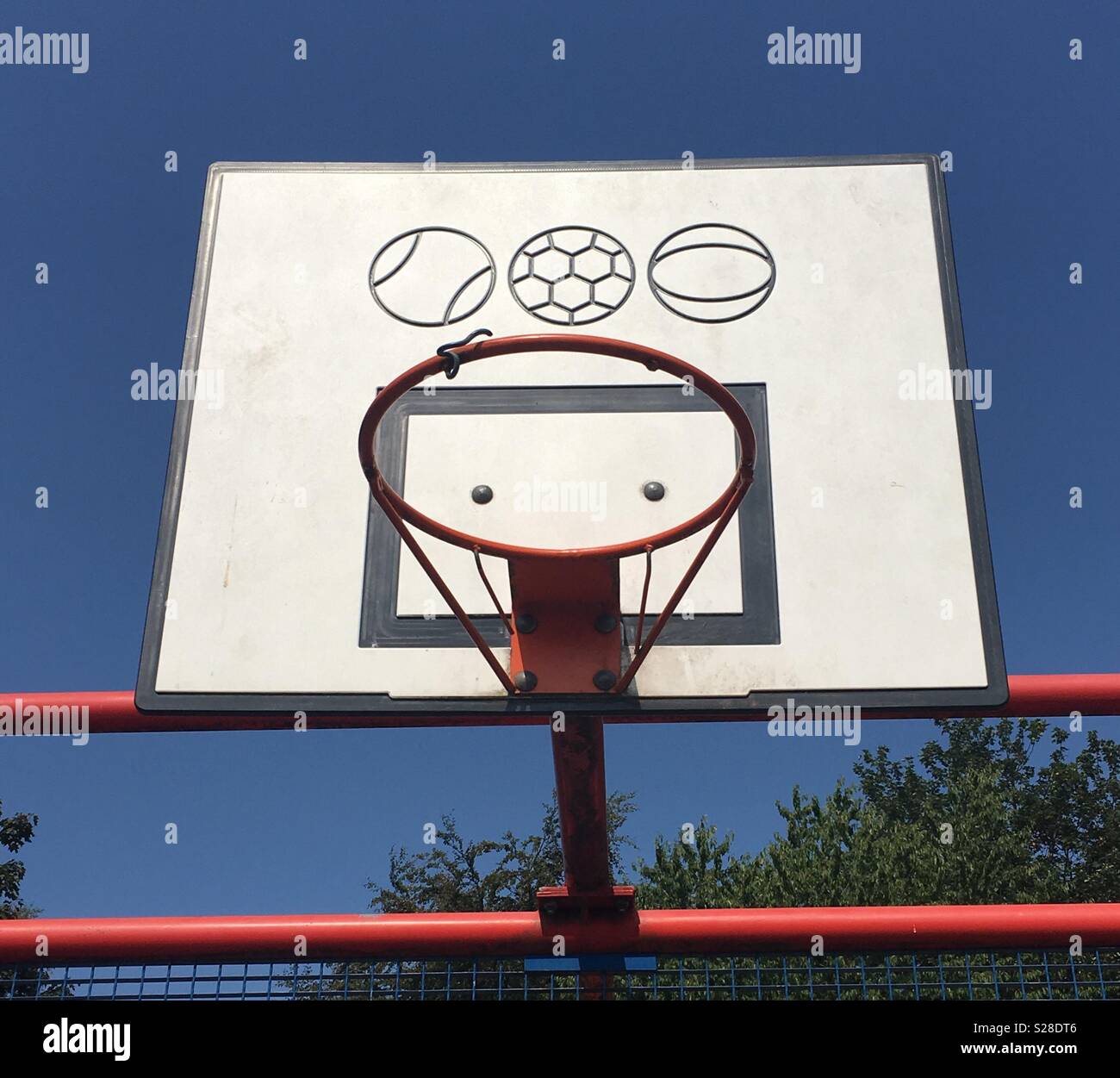 A basketball hoop (with no net) against a cloudless, deep blue summer sky. Stock Photo