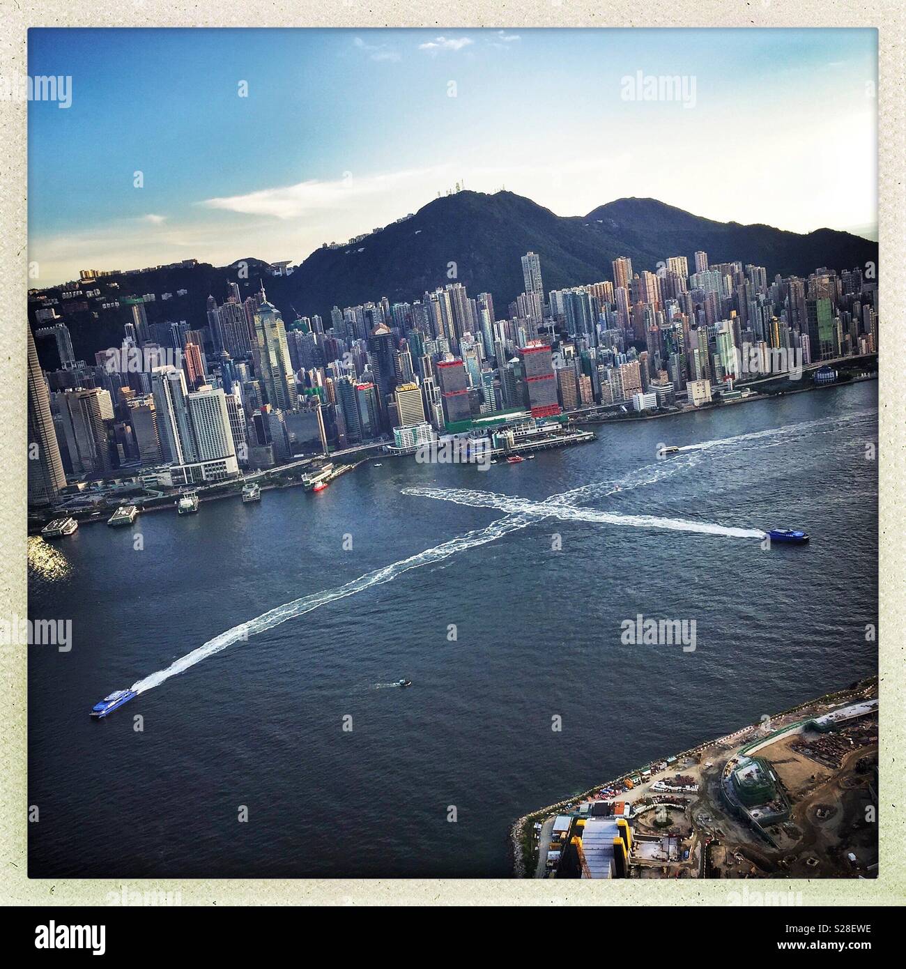 Passenger ferries on Victoria Harbour and the highrise of Hong Kong Island - Smartphone Captured Stock Image