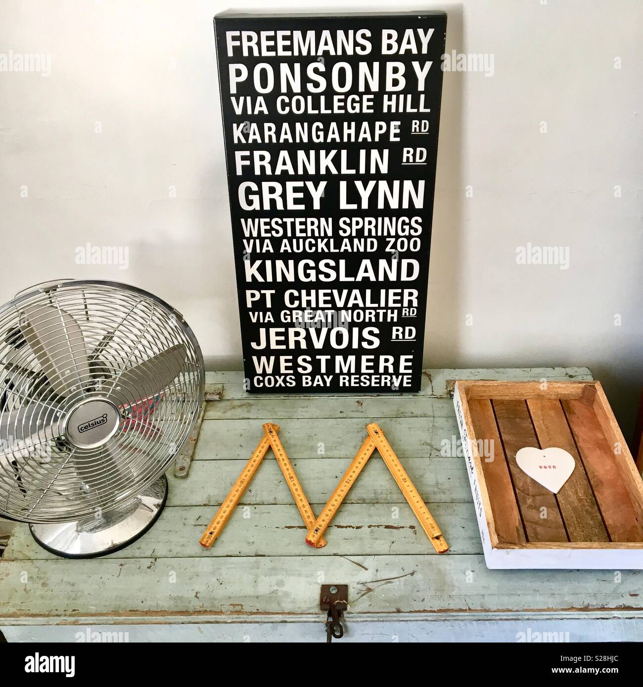Interior design with metal fan and Auckland places on canvas art on a rustic trunk box - Smartphone Captured Stock Image