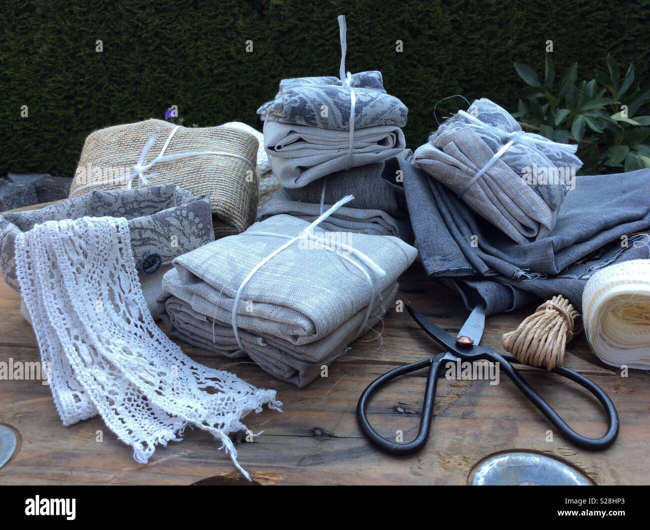 View on gift packages of vintage linen fabrics displayed on wooden table Stock Photo