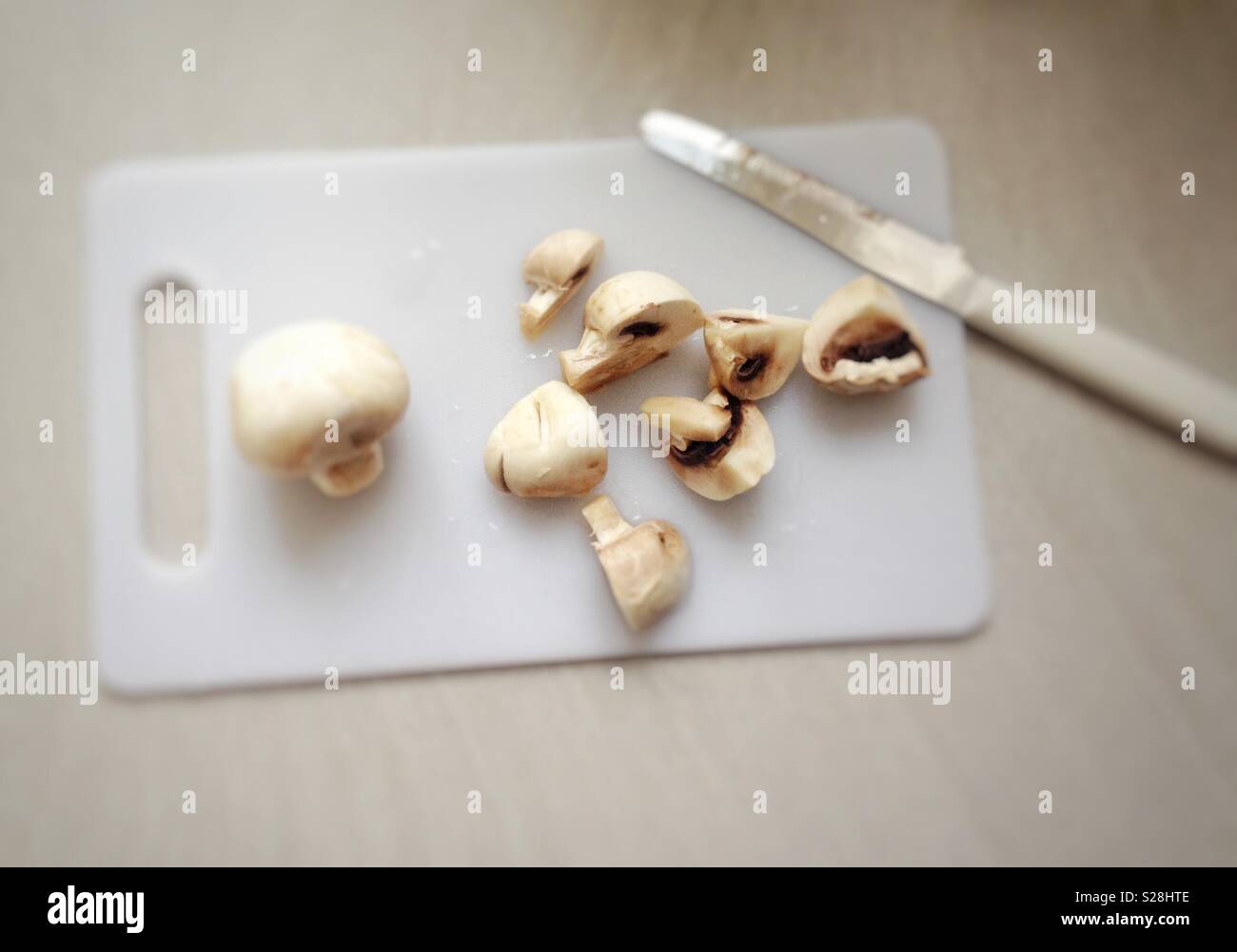 Sliced mushrooms on a white cutting board - Smartphone Captured Stock Image