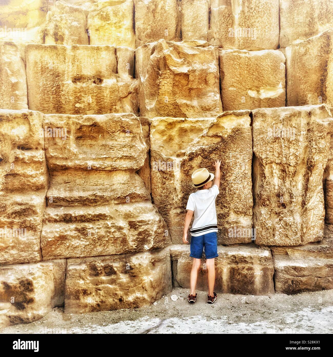 Boy measuring himself against Pyramid blocks - Smartphone Captured Stock Image