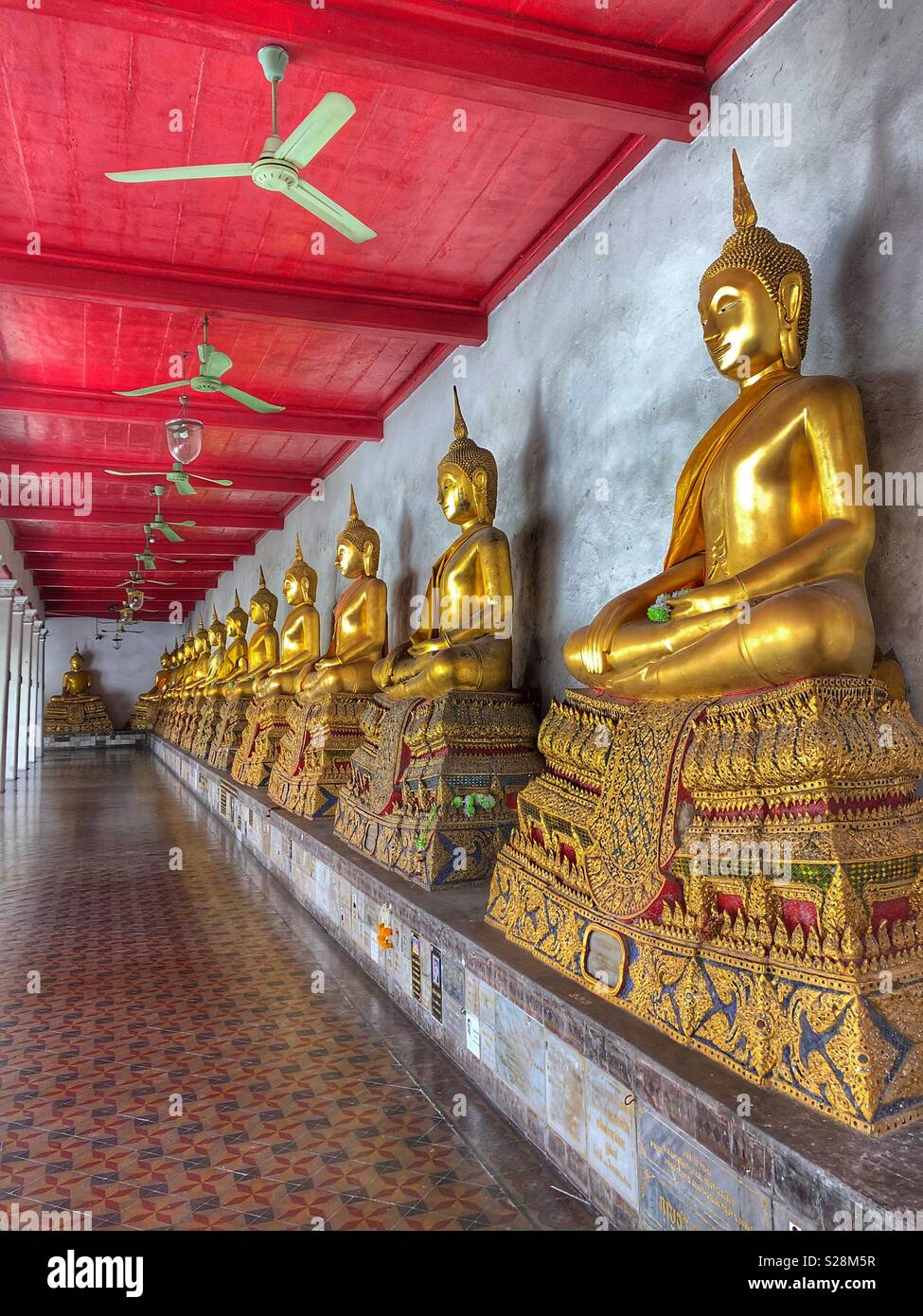 A row of sitting Buddhas in a Bangkok temple. - Smartphone Captured Stock Image