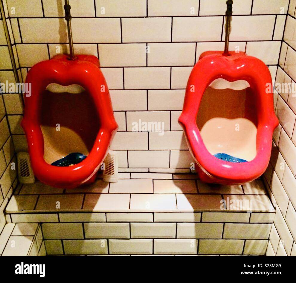 Men’s urinals in unusual novelty shape in British toilet Stock Photo