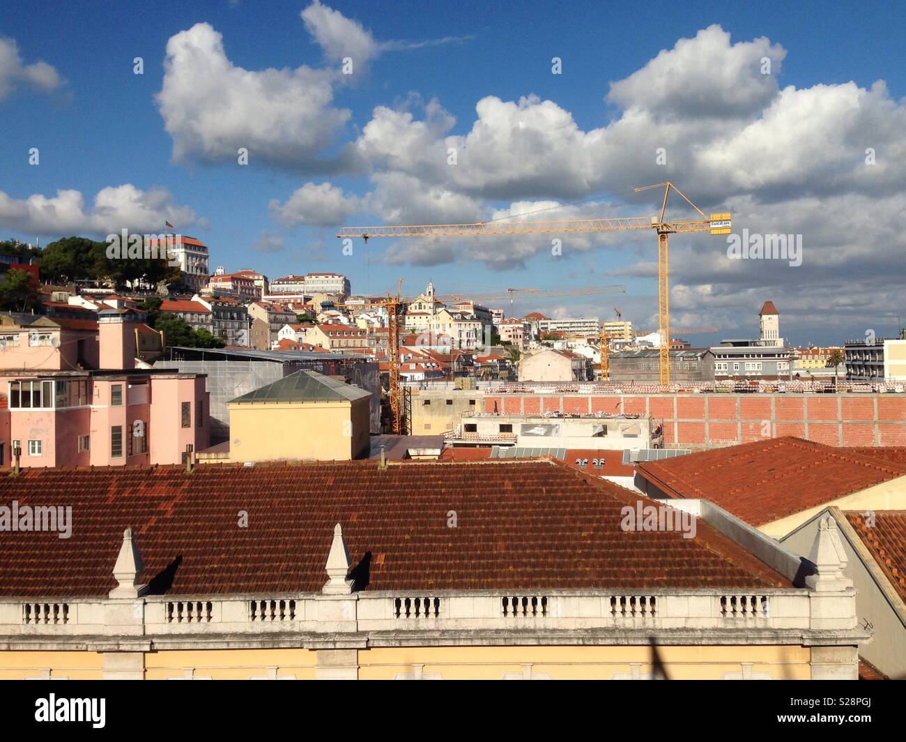 Rooftops in Lisbon, Portugal, under blue sky and low clouds Stock Photo